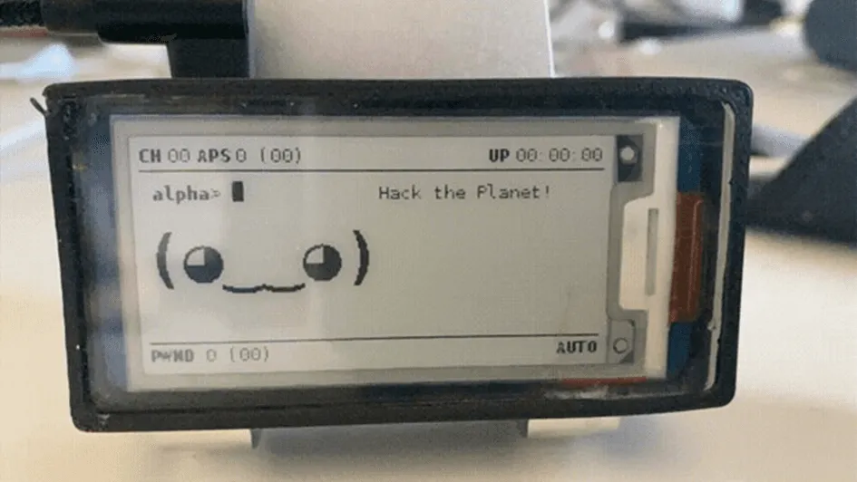 Photo of a Pwnagotchi device screen showing "Hack the Planet!", a smiley face and channel/AP/handshake counters.